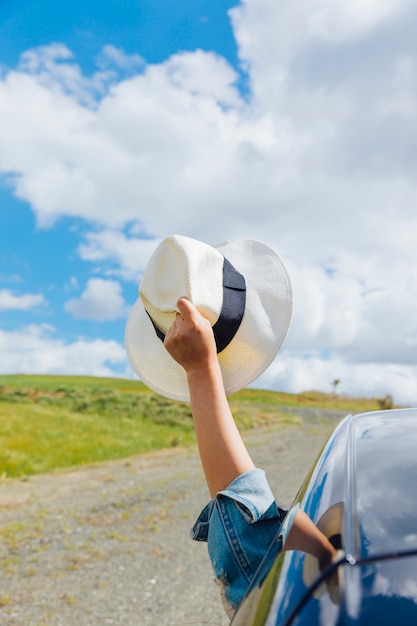 Foto gratuita mano di donna con cappello contro il cielo