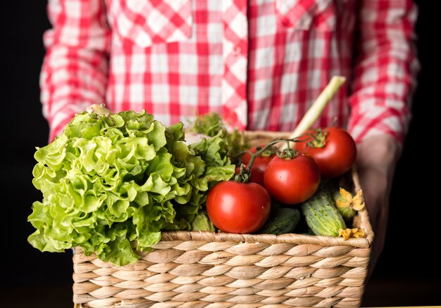 Woman holding a bucket of veggies