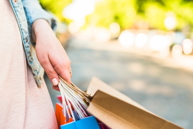 Free photo woman holding colourful shopping bags in hand