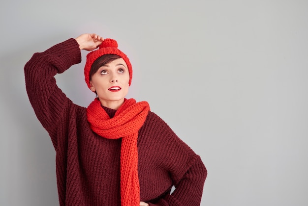 Free photo woman holding the end of her winter cap