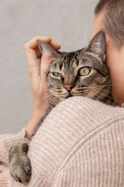 Woman holding her adorable kitty indoors