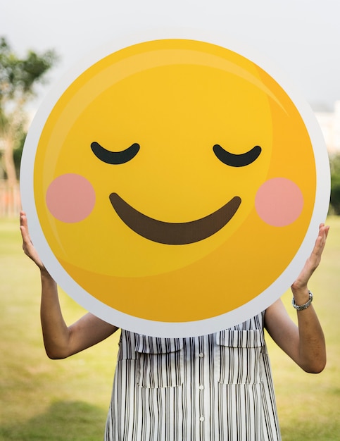 Free photo woman holding a smiley face icon