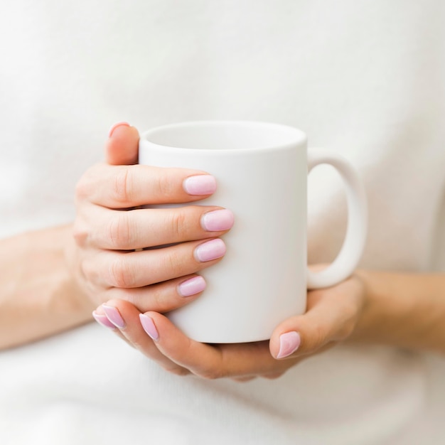 Free Photo woman holding white mug