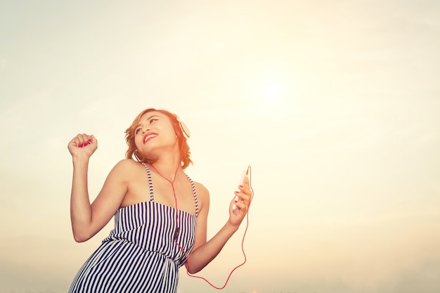 Free photo woman listening to music and dancing outdoors