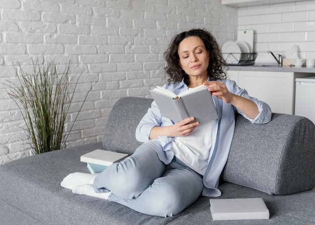 Woman reading on couch full shot