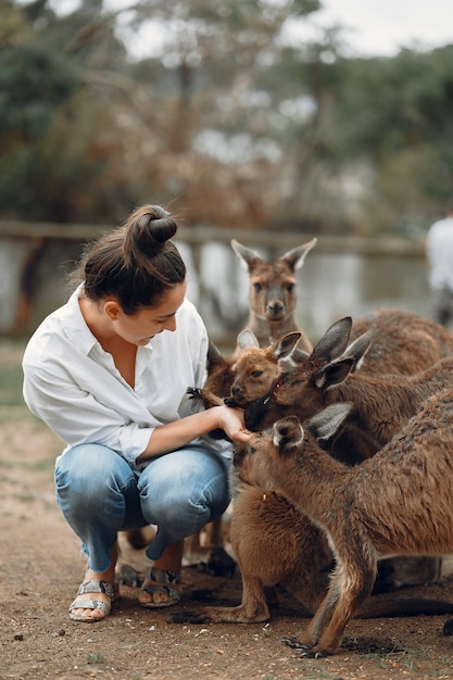 Free photo woman in the reserve is playing with a kangaroo