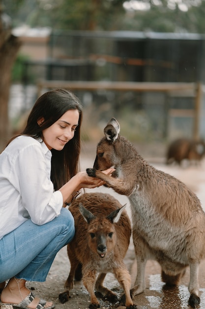 Free photo woman in the reserve is playing with a kangaroo