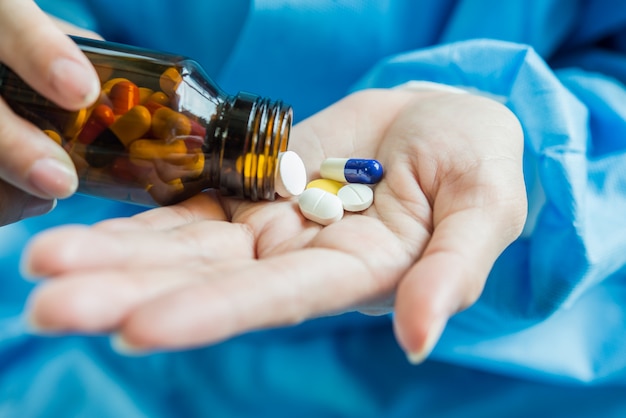 Free photo woman's hand pours the medicine pills out of the bottle