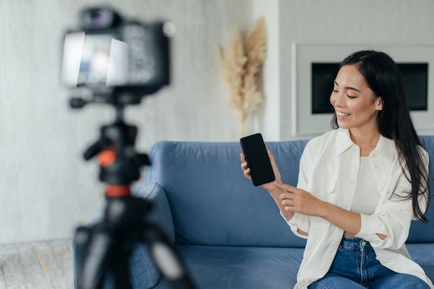 Woman showing her phone while vlogging