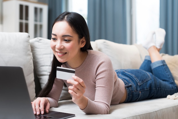 Free photo woman on sofa with credit card shopping online