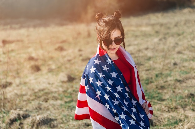 Woman in sunglasses throwing American flag over 