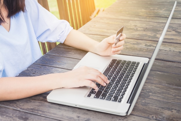 Free photo woman typing on a laptop and using a mobile phone