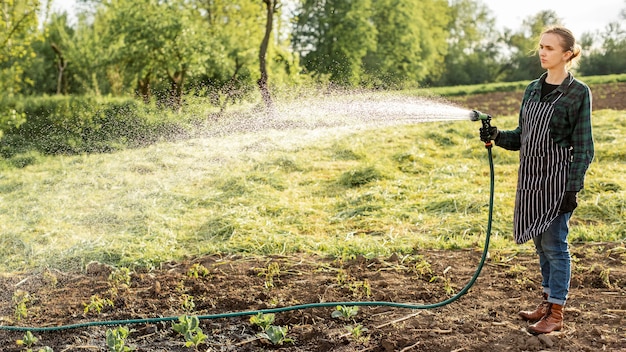 Free photo woman watering the crops