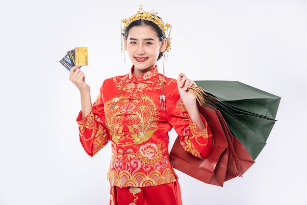 Free Photo woman wear cheongsam suit happy to use credit card shopping in chinese traditional day