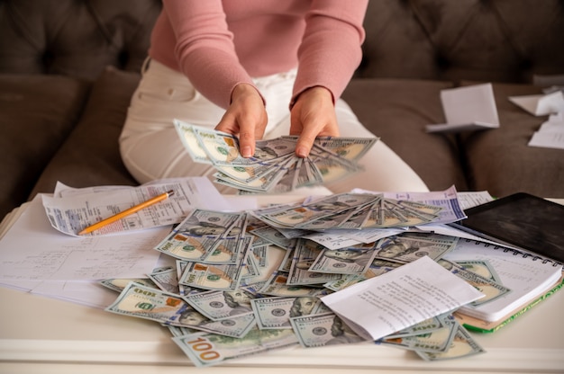 Woman wearing black glasses showing money