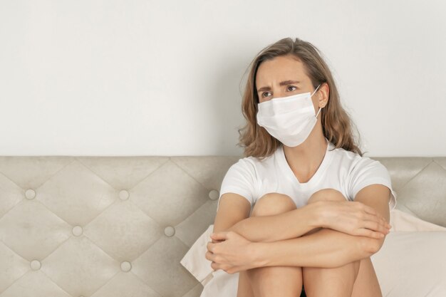 Free photo woman wearing face mask to protect  feeling sick headache and cough because of coronavirus covid-19 in quarantine room