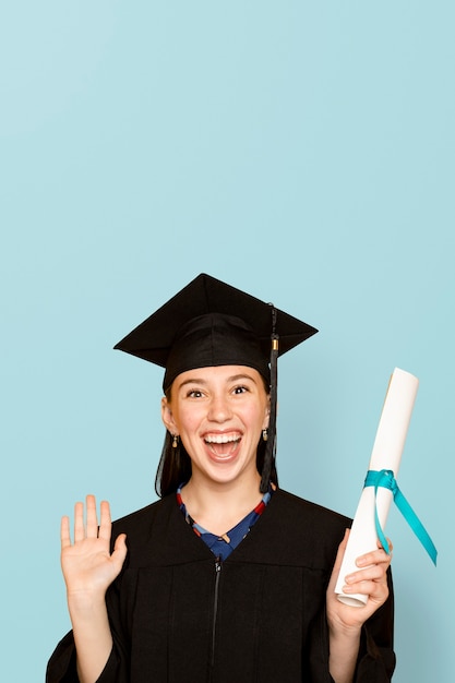 Free Photo woman wearing regalia holding her degree for graduation