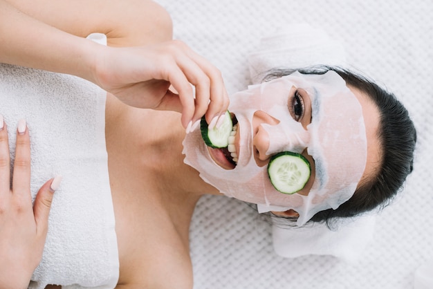 Free Photo woman with a cucumber mask