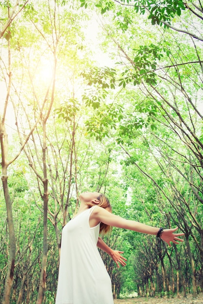 Foto gratuita donna con vestito allungando le braccia nella foresta