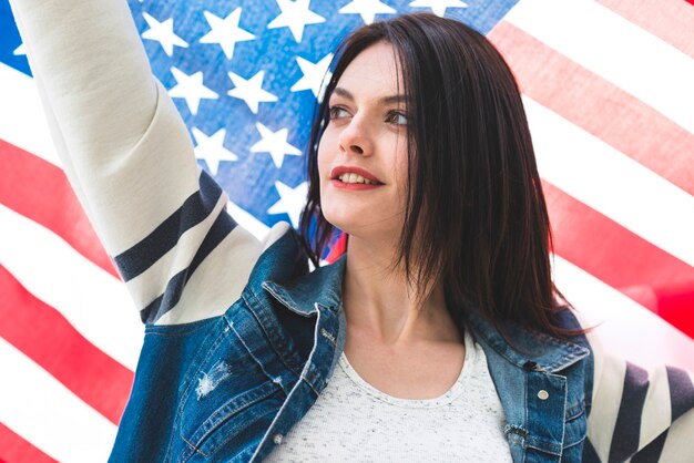 Woman with hand up and star-spangled flag