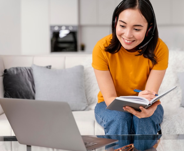 Free Photo woman with headset for video call on laptop