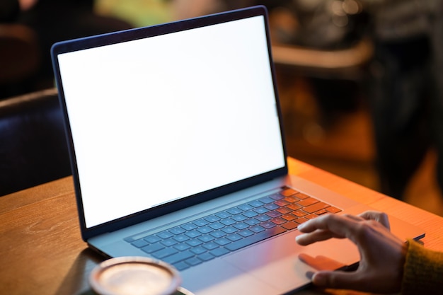 Woman working on her blank laptop in a coffee shop