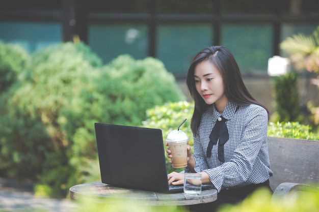 Free photo woman working on laptop in cafe and drinking coffee