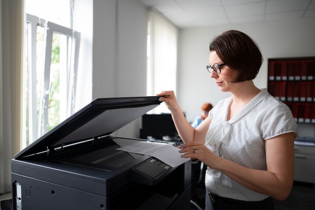 Free photo woman working in the office and using printer