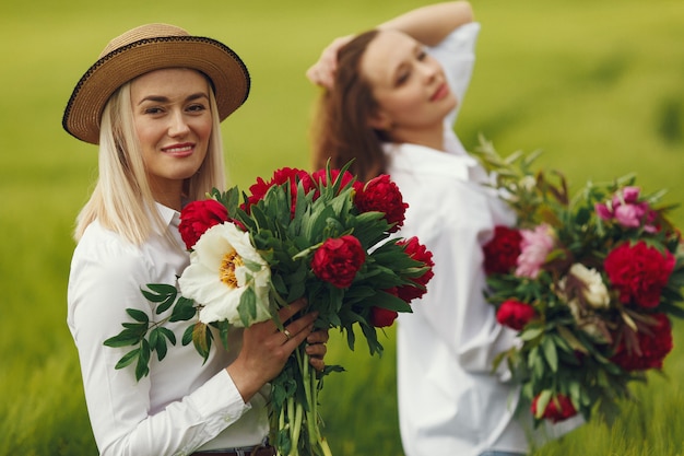 Free photo women in elegant clothes standing in a summer field