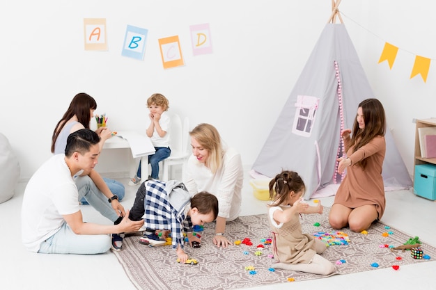 Free Photo women and man playing with children at home