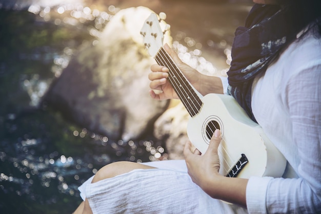 Foto gratuita le donne suonano l'ukulele nuovo alla cascata