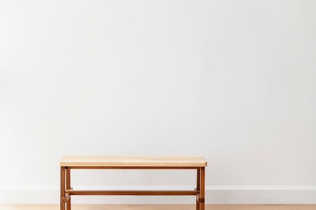 Free Photo wooden bench by a white wall