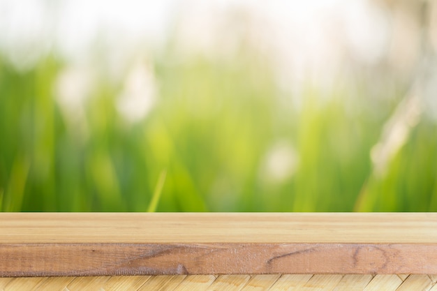 Free photo wooden board empty table in front of blurred background. perspective brown wood over blur trees in forest - can be used mock up for display or montage your products. spring season. vintage filtered.