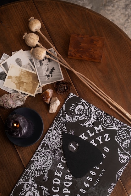 Free photo wooden ouija board and old photos flat lay