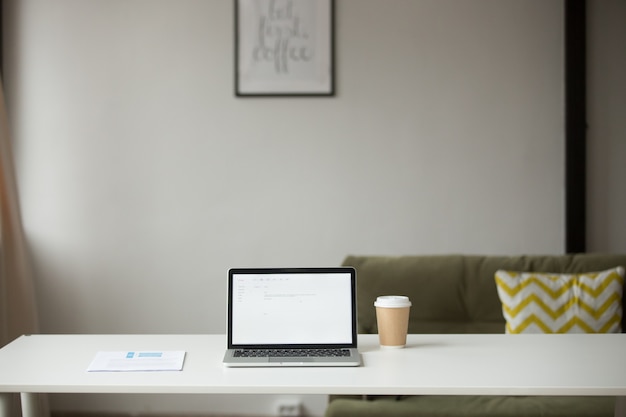 Free Photo working table with laptop, coffee and documents in home interior