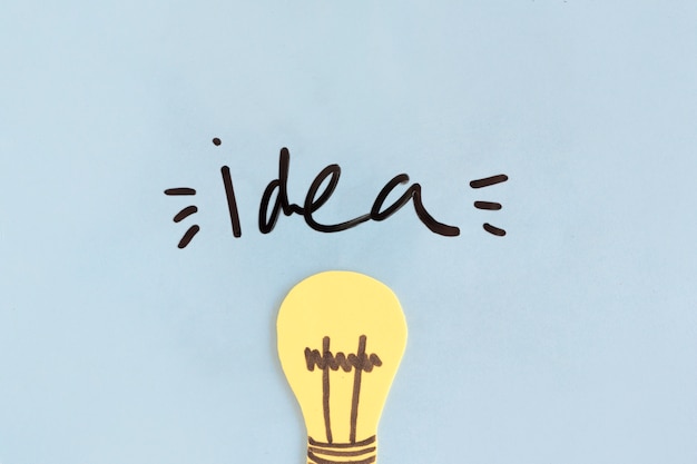 Free photo yellow light bulb with idea word on blue background