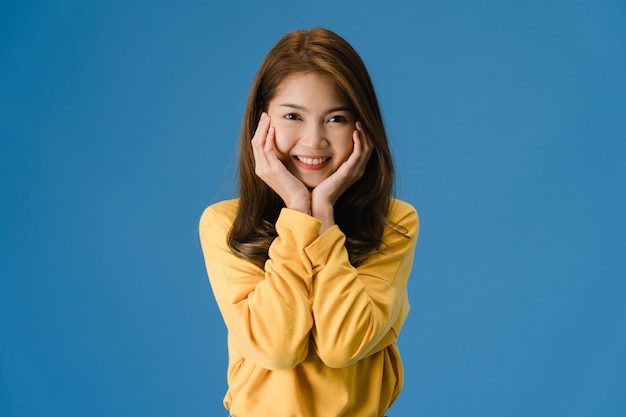 Free photo young asia lady with positive expression, smile broadly, dressed in casual cloth and look at camera isolated on blue background. happy adorable glad woman rejoices success. facial expression concept.