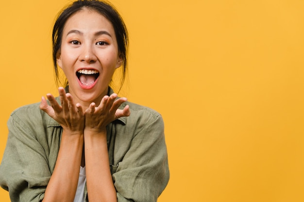 Free Photo young asian lady feel happiness with positive expression, joyful surprise funky, dressed in casual cloth  isolated on yellow wall. happy adorable glad woman rejoices success.