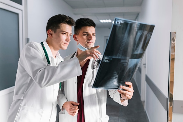 Free photo young doctors pointing at x-ray shot