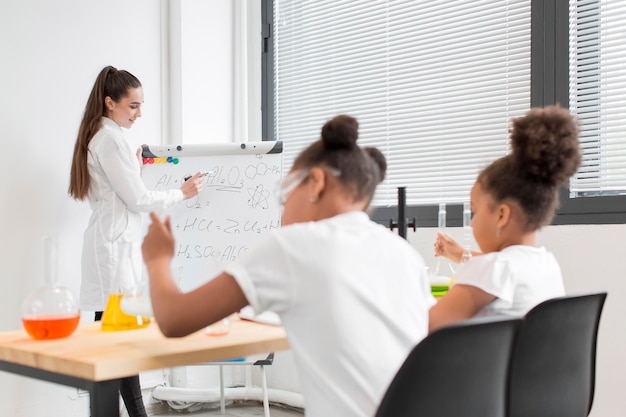 Foto gratuita ragazze che imparano sulla chimica dalla scienziata