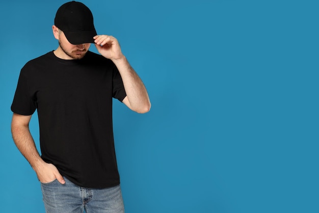 Free photo a young guy in a black tshirt and cap