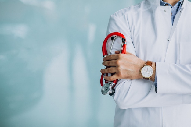 Foto gratuita giovane medico bello in un abito medico con lo stetoscopio