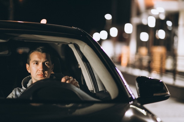 Free photo young man driving his car at a night time