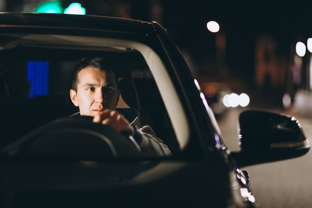 Free photo young man driving his car at a night time