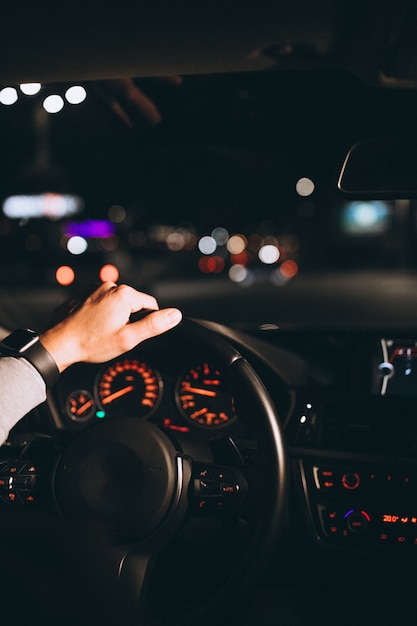 Free photo young man driving his car at a night time