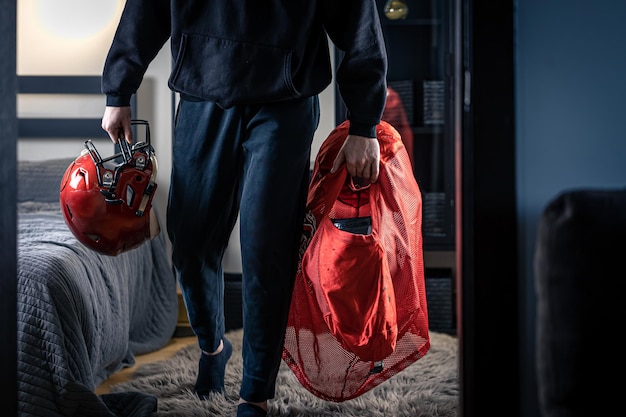 Free Photo a young man with a football helmet in his room