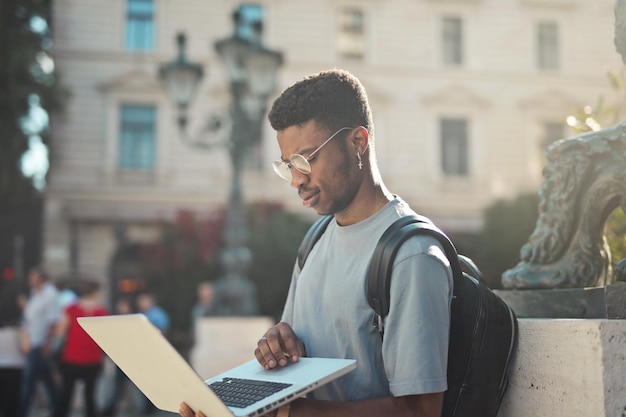 Free Photo young man works with a computer on the street