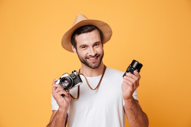 Free photo young smiling man looking camera while holding lens