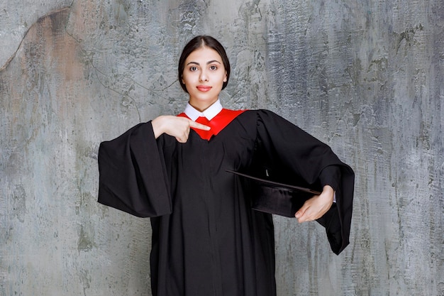 Free photo young student in gown posing for graduation day. high quality photo