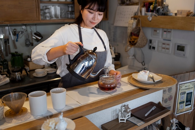 Free photo young woman arranging her cake shop